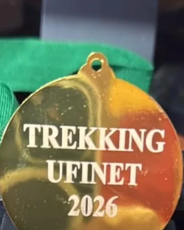 Trekking Ufinet 2026. Medalla dorada con el nombre y el año grabados.